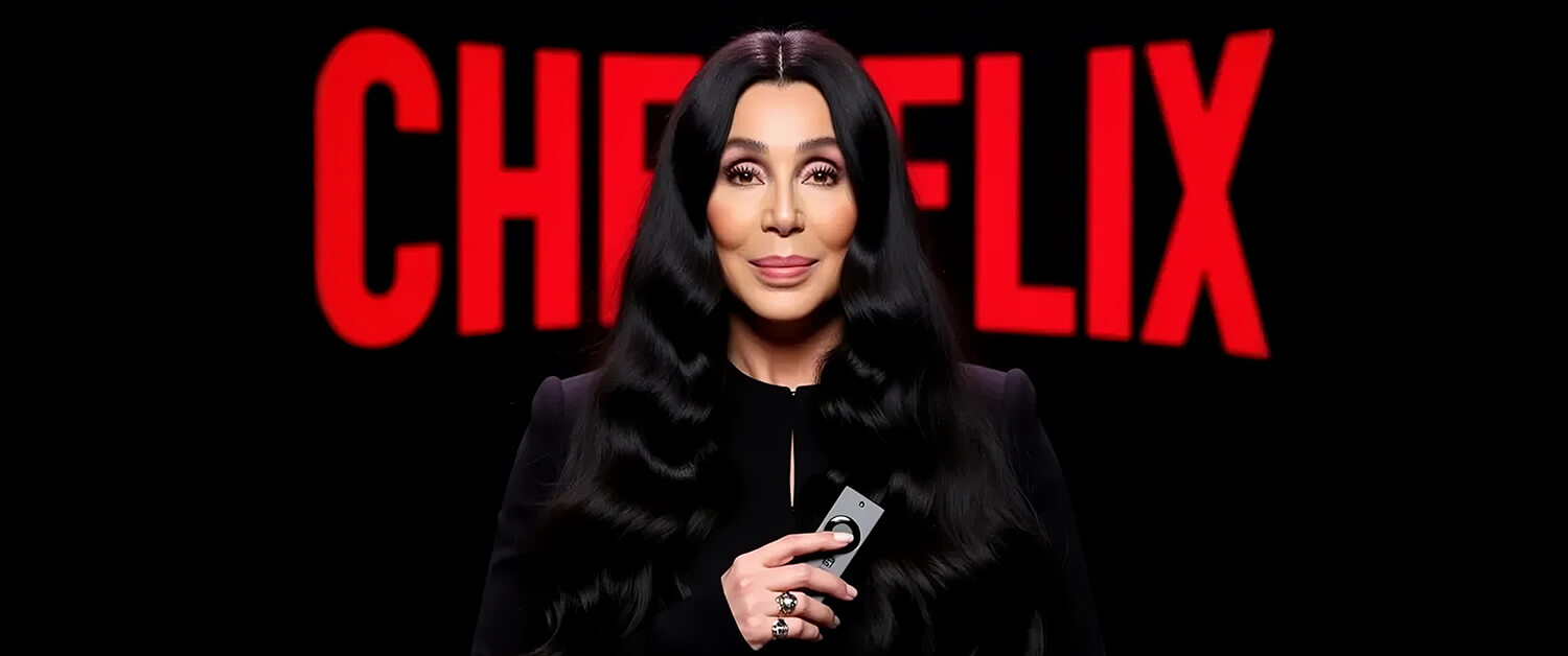 Cher, dressed in black with long wavy hair, holds a remote control in front of a black background featuring the red 'CHERFLIX' logo.